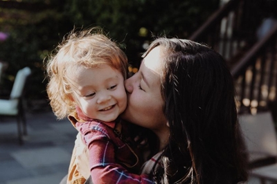 mother kissing her child on the cheek