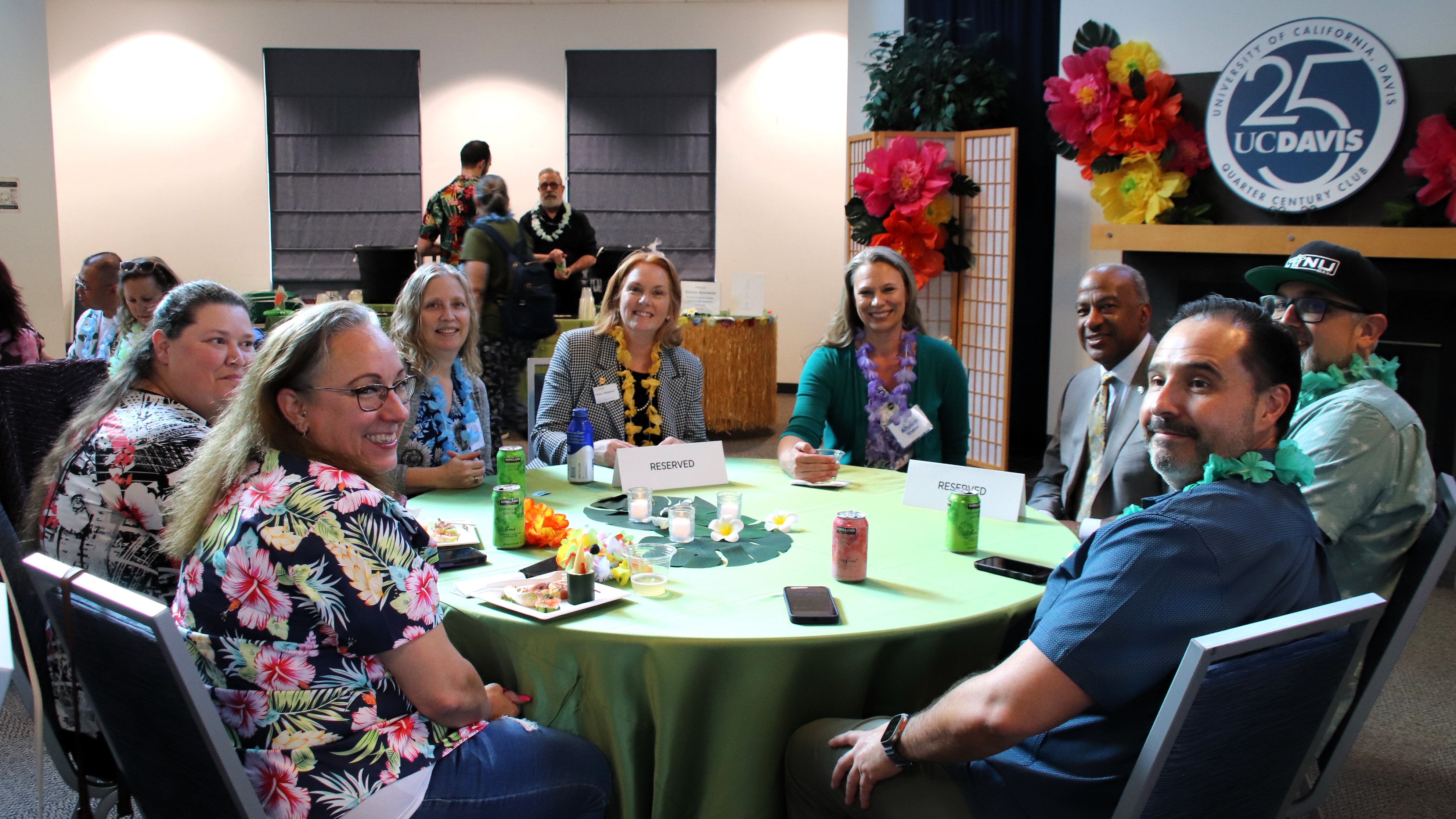 Clare Shinnerl and Gary May sit at a round table with employees.