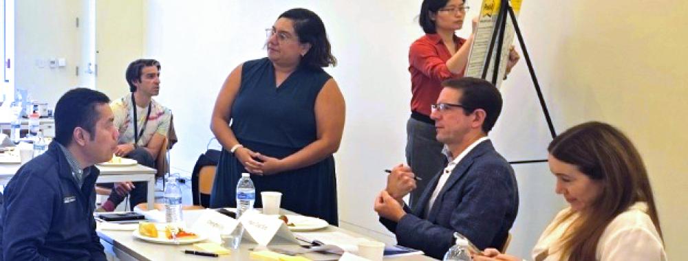 Men and women sit at a table during a learning course.