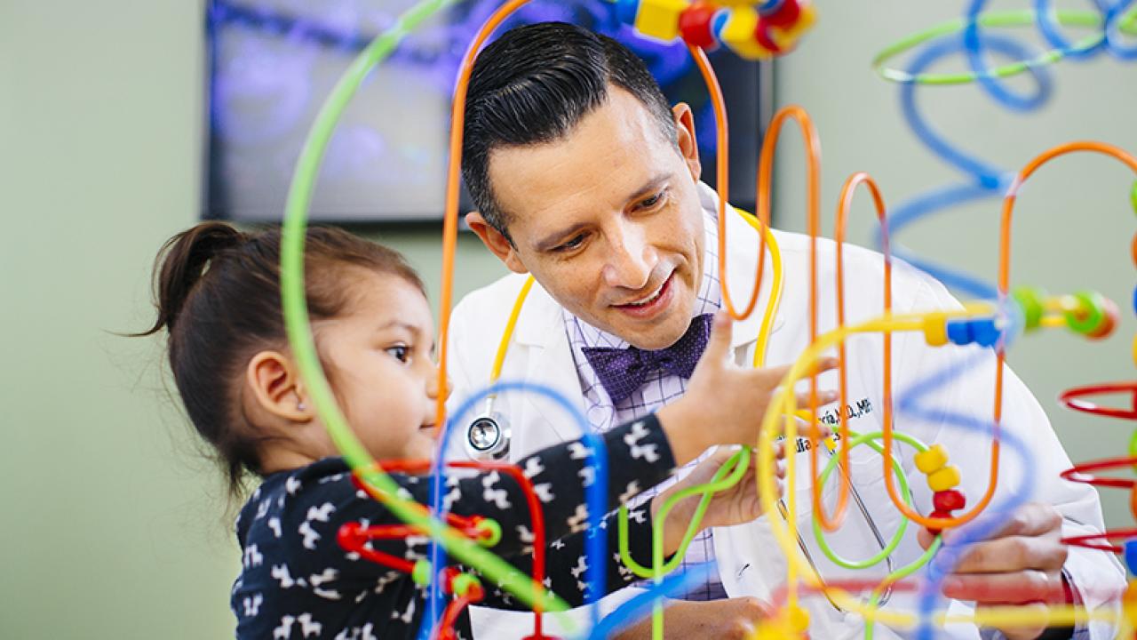 UC Davis Health doctor and child playing a dexterity game.