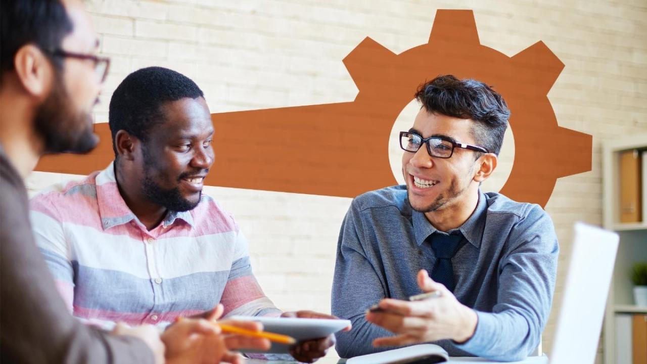 three people sitting at a table conversing