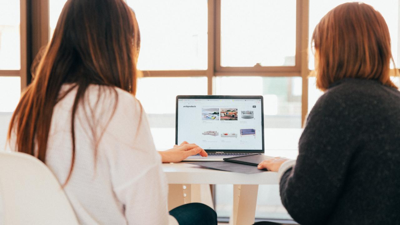 People looking at a laptop computer.