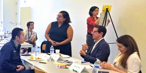 Men and women sit at a table during a learning course.