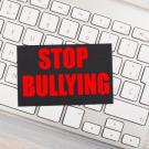 image of keyboard with text atop, reading Stop Bullying