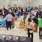 Overhead view of busy indoor expo hall with many people at tables and booths5